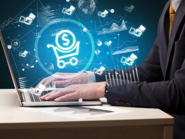 Geschäftsmann tippt auf Laptop mit E-Commerce-Symbolen
