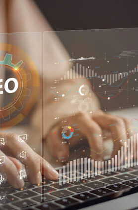 SEO-Optimierung und Datenanalyse Hände tippen auf einer Tastatur, umgeben von SEO-Grafiken.