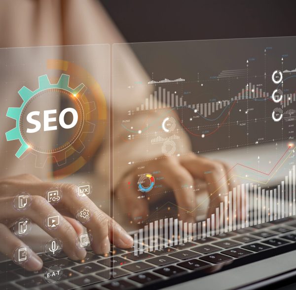 SEO-Optimierung und Datenanalyse Hände tippen auf einer Tastatur, umgeben von SEO-Grafiken.