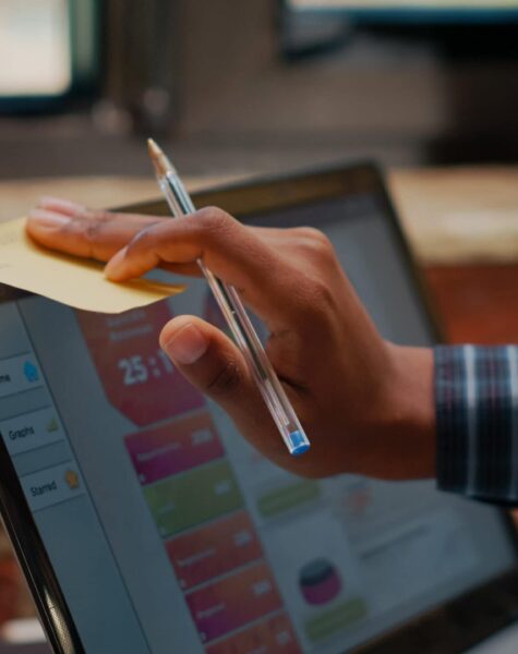 Employee putting sticky notes on laptop screen as work reminder Employee putting sticky notes on laptop screen as work reminder in company office. Manager using adhesive post it paper on display to remember business schedule and presentation. Close up