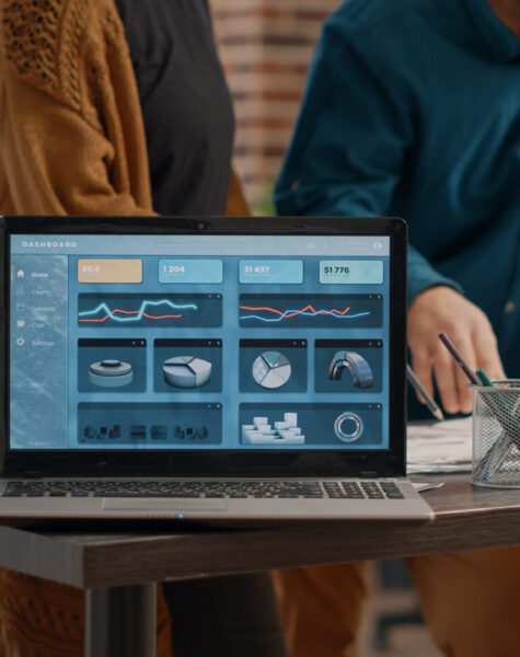 Close up of modern laptop with rate charts on display Close up of modern laptop with rate charts on display while man and woman working on business project design. Computer screen with data chart information and finance analysis on desk.