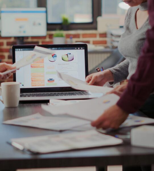 Business people looking at project reports on files to plan successful presentation with financial charts and results. Man and women working together to help with company growth. Close up