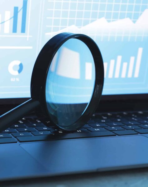 Magnifying glass on keyboard of laptop against light background, closeup Magnifying glass on keyboard of laptop against light background, closeup