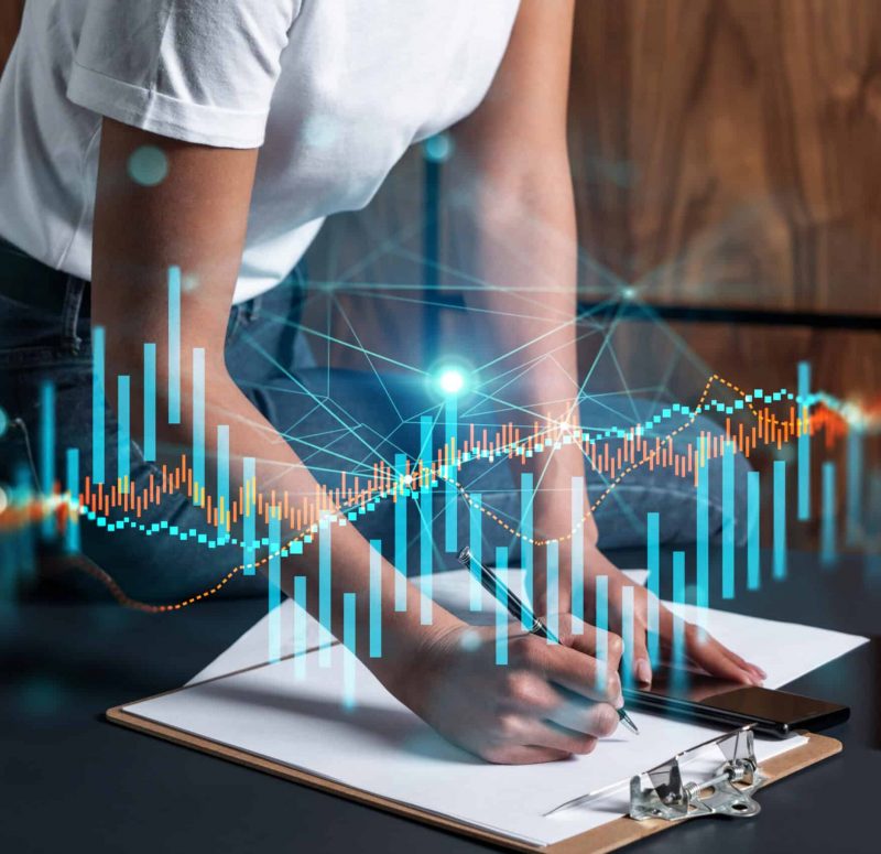 Datenanalyse und Notizen Person schreibt auf Papier, umgeben von digitalen Datenvisualisierungen.