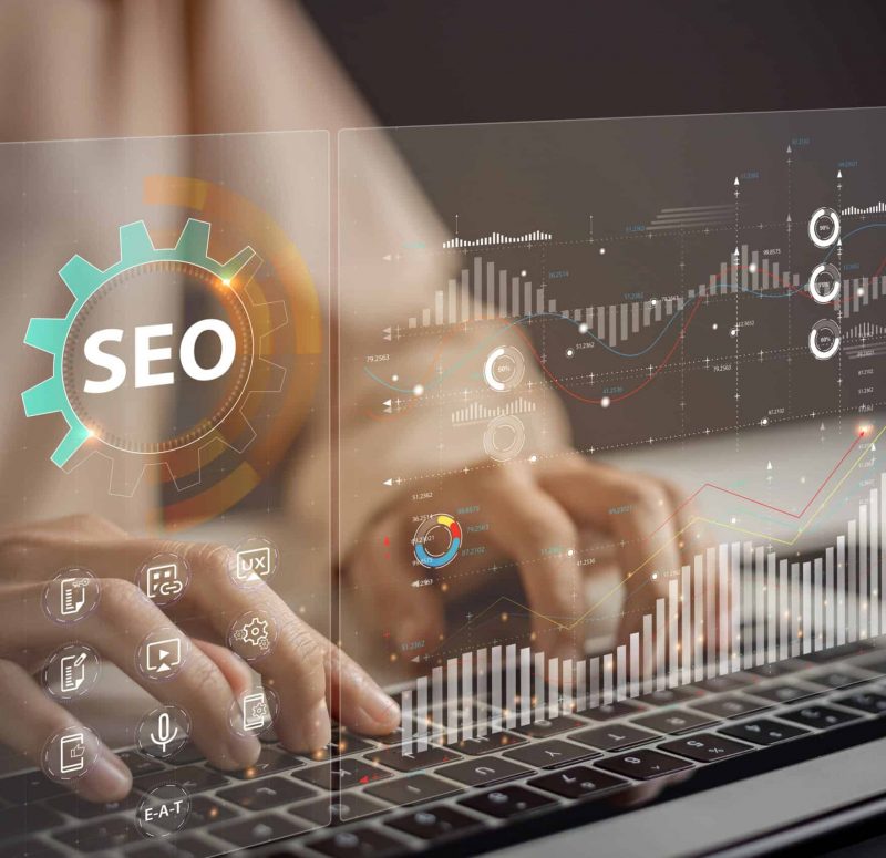 SEO-Optimierung und Datenanalyse Hände tippen auf einer Tastatur, umgeben von SEO-Grafiken.